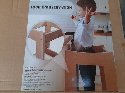 boîte en carton sur laquelle figure l'image d'un jeune garçon assis sur une chaise en bois
