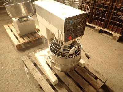 a mixer sitting on a pallet in a warehouse