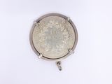 a close up of a silver coin on a white surface