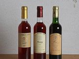three bottles of wine sitting on a table next to each other