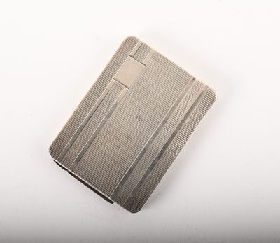 un vieux étui à cigarettes en argent posé sur une table blanche