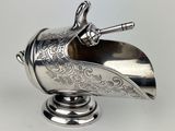 une lampe à huile ancienne en métal argenté, munie d'une poignée et d'une poignée