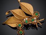 a gold and emerald broochle with leaves