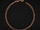 un bracelet en or avec un fermoir en forme de serpent sur fond noir