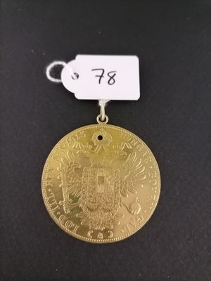 a gold medal with a white tag attached to it