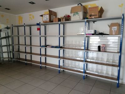 une pièce avec de nombreuses étagères et des cartons posés sur ces étagères