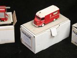 trois petits camions rouges posés sur une boîte