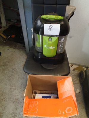 un aspirateur vert et noir posé sur une boîte en carton