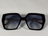 une paire de lunettes de soleil noires posée sur une surface blanche