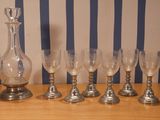 six verres à vin et une carafe posés sur une table