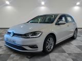 a white volkswagen golf is parked in a room with a checkered floor