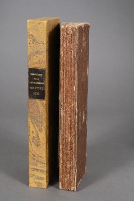 an old book sitting on top of a table next to another book