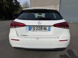 the rear end of a white car parked in a parking lot