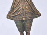 bronze figurine of a boy with a hat on his head