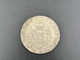 a close up of a silver coin on a black surface