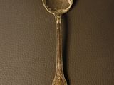 an old spoon sitting on top of a table next to a wall