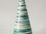 un vase bleu et blanc posé sur une surface blanche