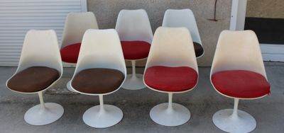 six chaises « Tulip » avec des coussins rouges devant une porte de garage