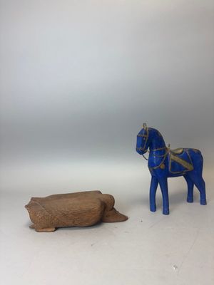 un cheval en peluche posé à côté d'une bûche