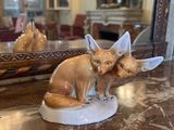 une figurine représentant deux renards assis sur une table