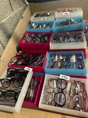 many pairs of eyeglasses in the boxes on the table