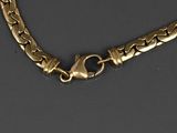 a close up of a gold chain on a black surface