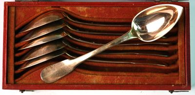 spoons and spoon rest in a red case with a white background