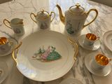 a picture of a table with a plate, cups, and teapots