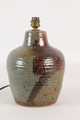 un vase marron et vert sur lequel est posée une lampe