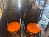 several orange chairs are lined up in a row in a restaurant