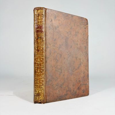 an old book sitting on top of a white table next to a white wall