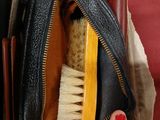 a person holding a brush inside of a purse