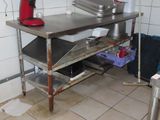 une photo d'une cuisine avec une table et un mixeur rouge