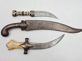two knives are sitting next to each other on a white surface