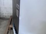 a white refrigerator sitting on a pallet in a room