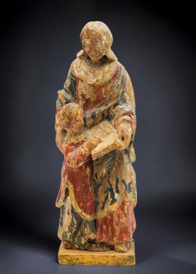 une statue ancienne d'une femme tenant un bébé dans ses bras