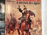 three books on a bed with a white sheet with a picture of a man on a horse