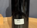 a bottle of wine sitting on a table next to a wooden block