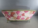 a pink and green couch with a floral pattern on it