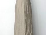 La robe est en lin et présente un décolleté froncé.