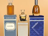three bottles of perfume sitting on top of each other on a table