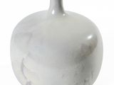 un vase blanc posé sur une surface blanche