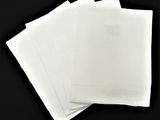 quatre serviettes blanches sur une table noire, sur fond noir