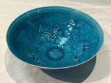 a blue bowl with a design on it sitting on a table