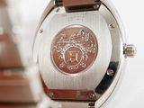 a close up of a wrist watch with a coin on it