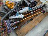 un tas d'aspirateurs et d'autres articles ménagers par terre