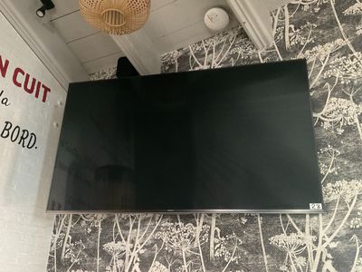 une télévision à écran plat fixée au mur au-dessus d'une table