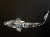 une sculpture de requin en verre transparent sur fond noir
