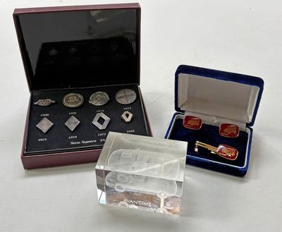 two silver and red jewelry items in a case on a white surface