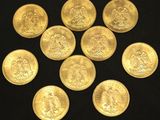 six gold sovereigns are arranged in a circle on a black surface